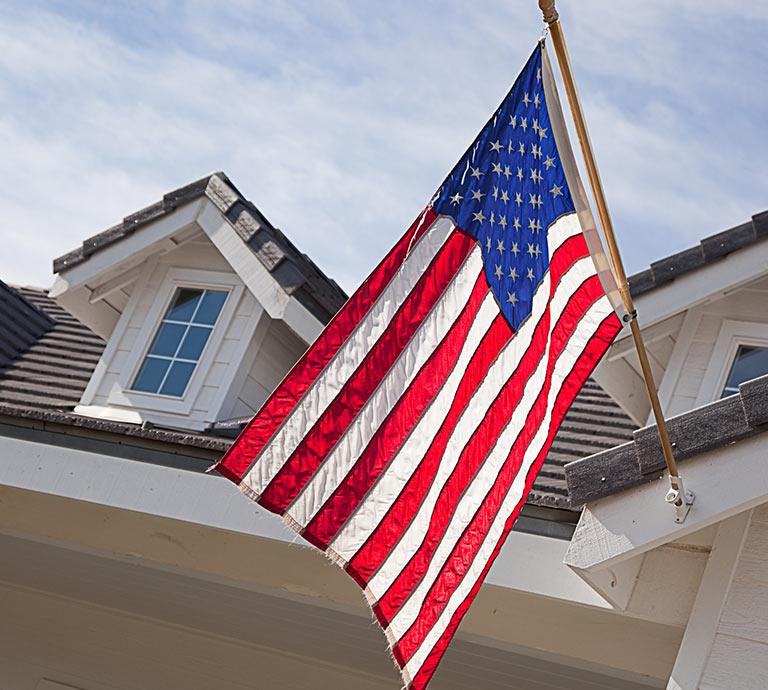 An American Flag Hanging from Home with Home Insurance in Dundee, Ida, Monroe, Newport, Temperance